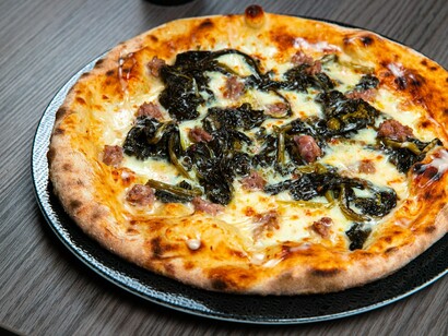 Pizza con salsiccia e friarielli. I friarielli sono un contorno tradizionale della cucina napoletana, spesso abbinati alla salsiccia e utilizzati come ripieno per pizze e calzoni