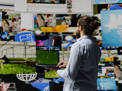 Individual surrounded by glowing screens, isolated and overwhelmed by constant online exposure