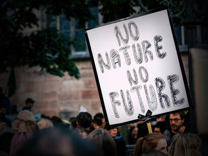 Cartel en una manifestación que dice: 'Sin naturaleza no hay futuro'. Explora las contradicciones y desafíos en la narrativa del cambio climático y la ciencia