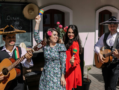 A woman dances gracefully while men in sombreros play guitars in the background