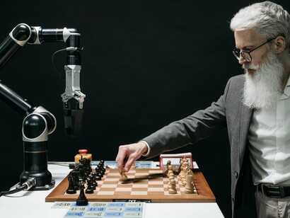 Homem joga xadrez com um robô. A inteligência artificial não consegue replicar a complexidade sensorial humana e aprofundar a nossa consciência com mergulhos profundos no nosso autoconhecimento