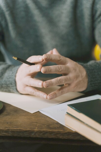 A writer contemplating with his hands, about what to write next