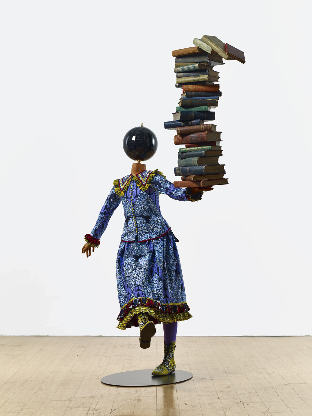 Yinka Shonibare MBE b. 1962, Girl Balancing Knowledge (2015)
Fibreglass mannequin, Dutch wax printed cotton textile, books, globe and steel baseplate
179 x 139 x 89 cm (70 1/2 x 54 3/4 x 35 in.)
Photographer: Stephen White
Image courtesy the artist, Stephen Friedman Gallery,
London and Pearl Lam Galleries, Hong Kong, Shanghai
and Singapore
