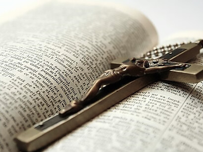 A crucifix positioned atop an open Bible