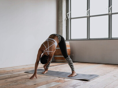 Mujer practica yoga en un conjunto estampado con un top de tiras en la espalda