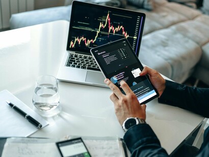 A professional navigating fast-moving financial data on portable technology, symbolising agile and scalable fintech infrastructure