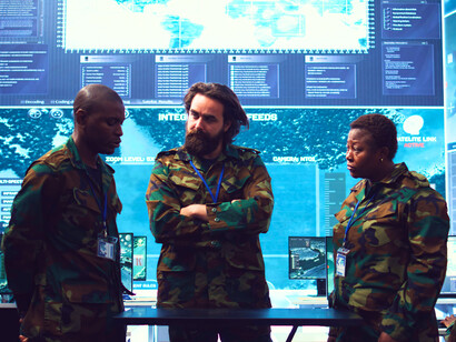 A command team engaged in discussion, representing the collaboration that drives modern defence strategies