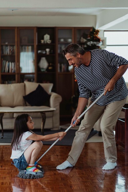 Man and daughter make a game out of sweeping the floor
