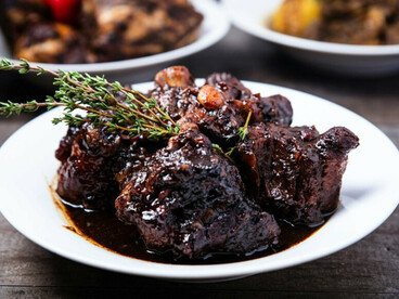 A richly braised oxtail dish presented with gourmet styling, representing the transformation of a humble staple into a premium menu item