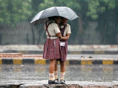 Dos niñas con un paraguas bajo la lluvia
