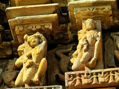 Relief carving of Gandharvas, divine dancers, adorns the wall of the Chaturbhuja Temple in Khajuraho, India. This intricate artwork highlights their celestial grace and connection to divine music and dance