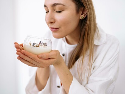 A woman holding a scented candle hoping that it will trigger a vision