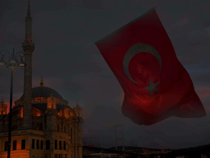 Istanbul's Sultanahmet Mosque is in the background as the Turkish flag swirls in the sunset sky