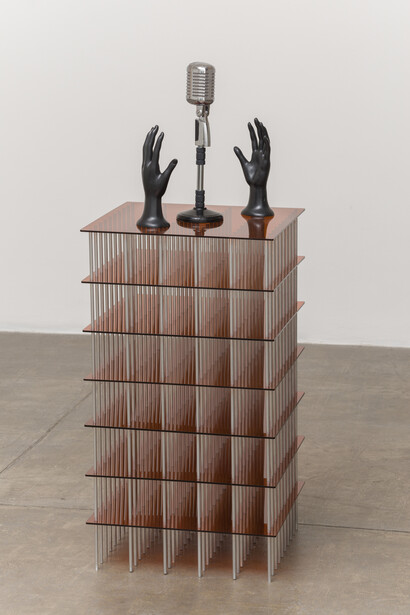 Rodrigo Matheus, Discurso, 2015, Plexiglass and aluminum structure, plastic hands, microphone and pedestal, 116 x 45 x 45 cm. Photo: Eduardo Ortega, Courtesy Galeria Fortes Vilaça
