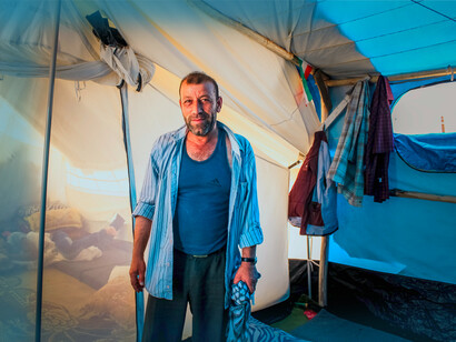 An Iranian father stands in the tent of an Iranian Refugee camp, in Samawah, Iraq