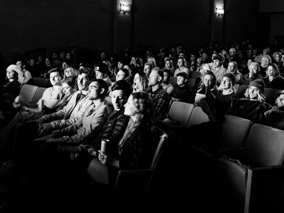 A black-and-white photograph of a crowd in a cinema