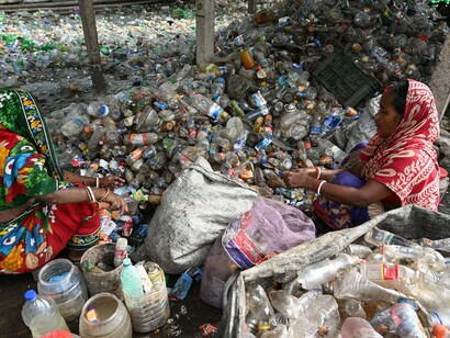 Two women sorting through plastic bottles