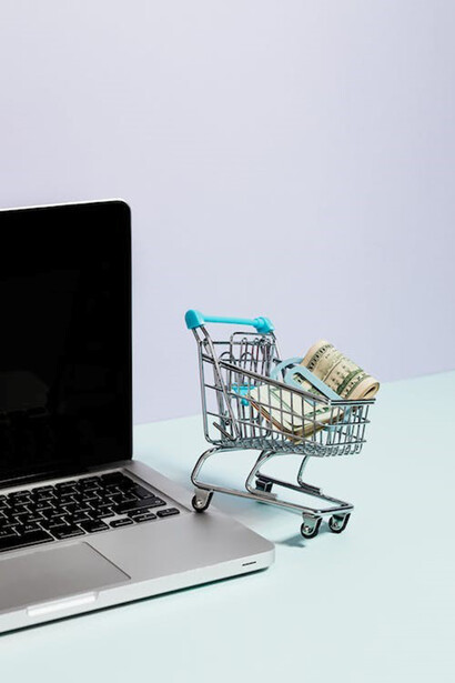 An illustrative depiction of a trolley displayed on a laptop with a money in it