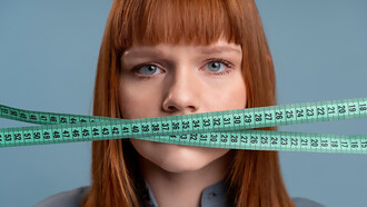 The personal struggle of a woman grappling with an eating disorder and weight issues, portrayed by holding a tape measure against her mouth, shedding light on the individual's journey and the complexities of body image and self-esteem