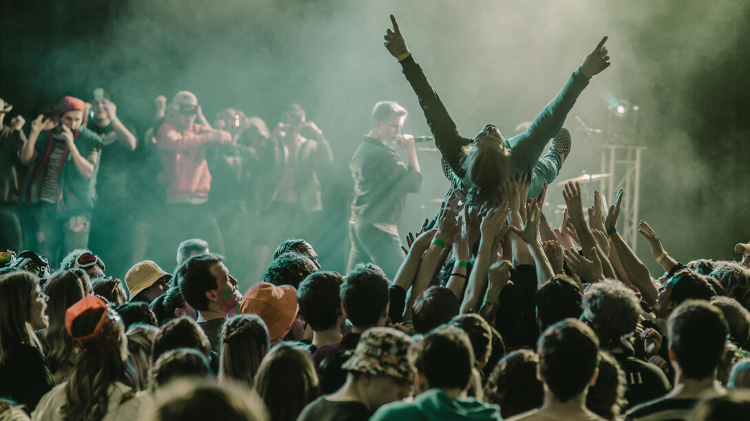Pessoas de idades diferentes curtem show em festival de música que mescla diferentes gêneros e artistas em um só palco