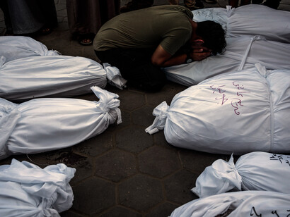 Hombre llora entre los cadáveres de las víctimas de los bombardeos en Gaza por parte de Israel