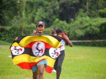 Man showing pride in Uganda culture with flag