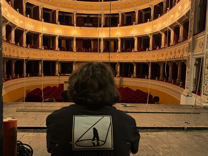 Sulla maglietta la figura stilizzata di Guido Levi in un cono di luce. È la foto simbolo dell’associazione Guido Levi Lighting Lab, fondata per dare opportunità concrete ai giovani, in ricordo del grande Lucifero scomparso nel 2019