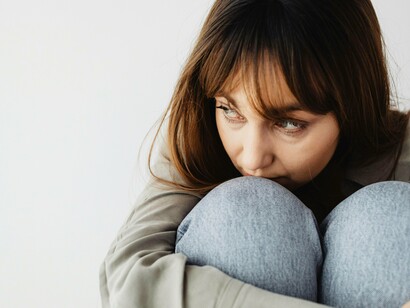 Femme assise et embrassant ses jambes