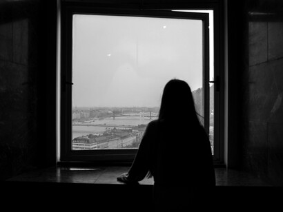 A silhouetted figure standing near a window