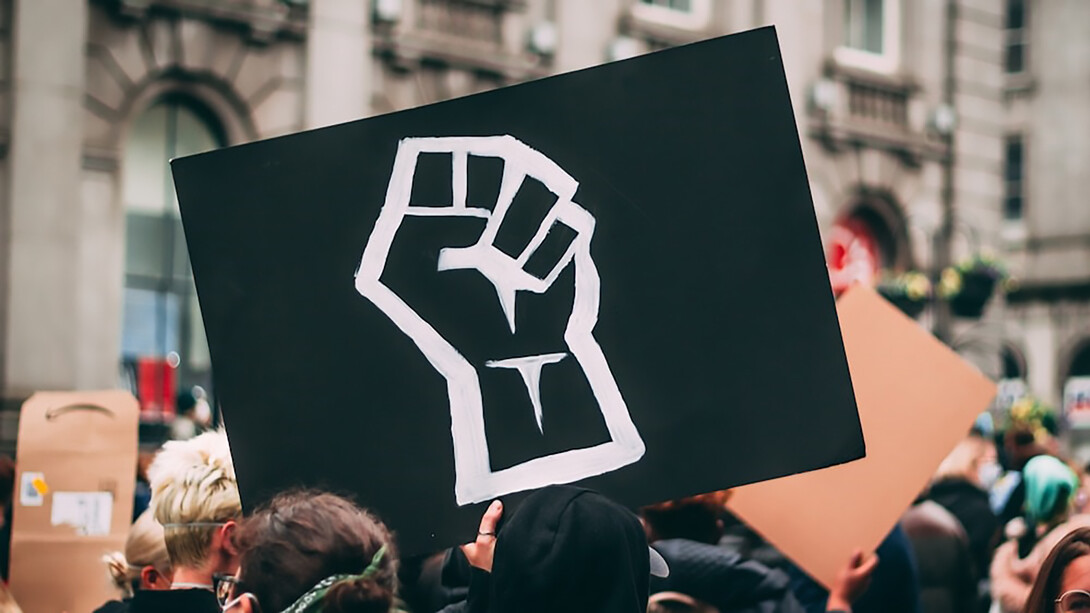 A protester holding a sign adorned with a raised fist symbolizes solidarity at a Black Lives Matter protest in Aberdeen, Scotland, on June 13, 2020