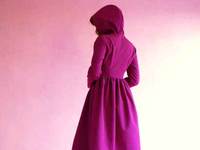 Joven en abrigo con capucha color rosa