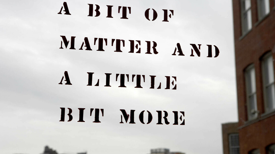 Lawrence Weiner: A bit of matter and a little bit more
Originally part of the exhibition Rooms in 1976, Lawrence Weiner wrote the title phrase on the inside of the front entrance as well as on the outside of the back door of MoMA PS1. The original doors, made of wood and metal, were removed during the renovation in 1997. After the renovation was completed, the artist was invited back to recreate the piece on both sides of the glass windows of the front doors.

Lawrence Weiner. A bit of matter and a little bit more. 1976. © 2017 Lawrence Weiner. Photo: Matthew Septimus
