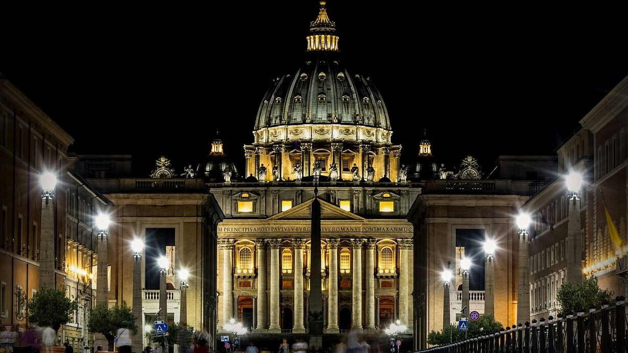 Spettacolare profilo della basilica di San Pietro illuminato dalle luci della sera, Roma, Italia. L'attuale basilica di San Pietro è frutto di più di due secoli di febbrili realizzazioni. L'obelisco che attualmente svetta maestoso al centro di Piazza San Pietro, il secondo per altezza a Roma, venne fatto trasportare dall' Egitto a Roma da Caligola