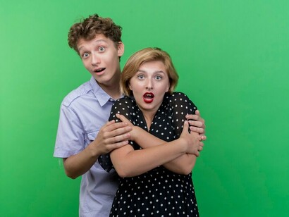 A young, beautiful couple looks surprised together, sharing a moment of shock and excitement