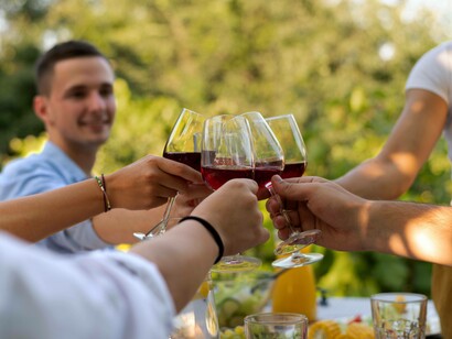 Gruppo di amici che brindano con calici di vino risso: "Il gusto non è mai statico. Ciò che oggi è considerato “buono” non lo era necessariamente vent’anni fa, e viceversa"