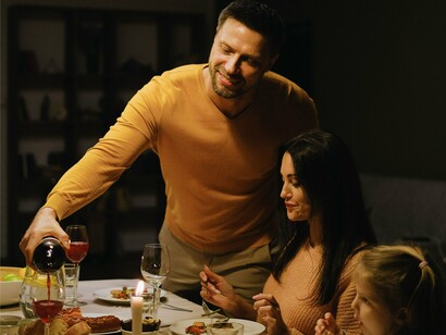 Taça sendo servida e sorrisos discretos marcam um momento de convivência e conexão. Refeições compartilhadas fortalecem vínculos e criam memórias que permanecem por toda a vida