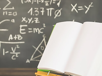 Opened book on book holder near blackboard