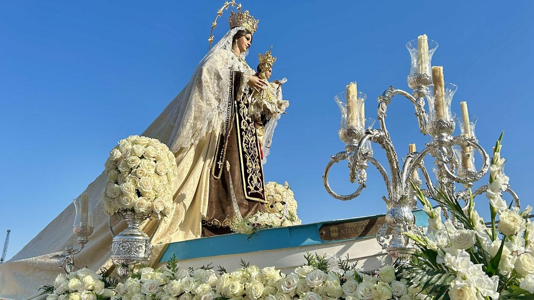L'image montre une statue religieuse, spécifiquement identifiée comme une statue de la Vierge Carmen lors d'une procession dans la ville d'Andalousie, en Espagne