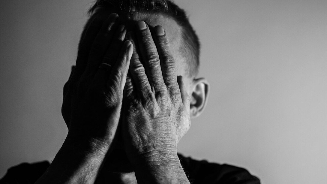 A man touching his face in depressed mode