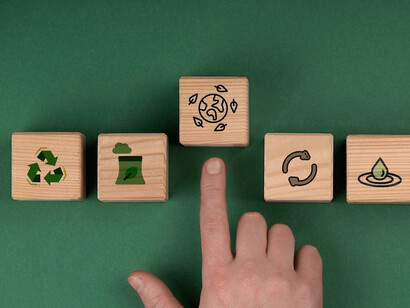 Each sustainability icon carved into wood highlights a key business priority, reducing waste, conserving resources, and investing in a greener future