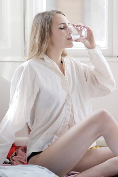 A woman is seen quenching her thirst as she drinks water