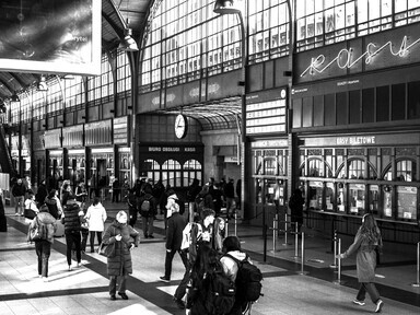 Busy train station interior with blurred crowds in motion