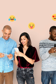 Individuals happily engage with digital devices, displaying smileys overhead, highlighting the intersection of technology, communication, and human connection amidst concerns of smartphone addiction and social media engagement