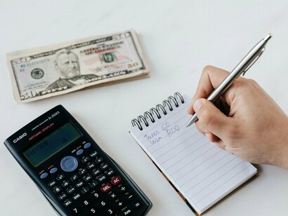 A taxpayer noting figures on a sheet, signifying how legislation translates into daily life