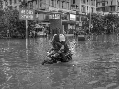 In the midst of a flood, a lone rider speeds ahead, a poignant reminder of our collective apathy towards global governance and environmental decay