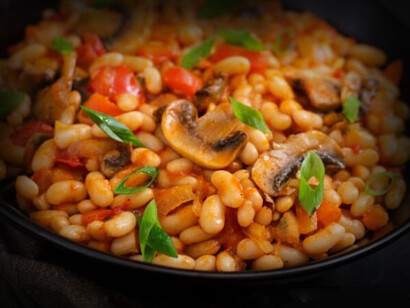 Un plato de frijoles blancos guisado con carne y champiñones