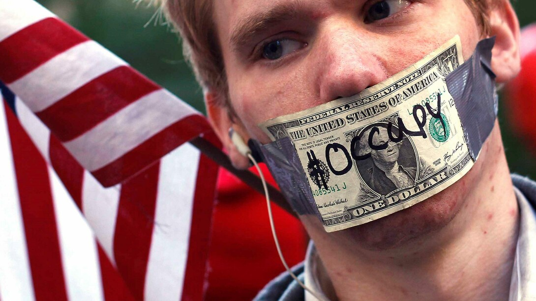 Activista del movimiento "Occupy Wall Street" con la boca tapada