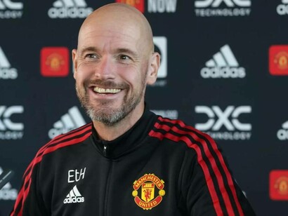 Erik ten Hag laughing from a question by a reporter at a press conference
