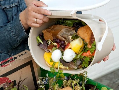 Tirando a la basura un cubo lleno de comida
