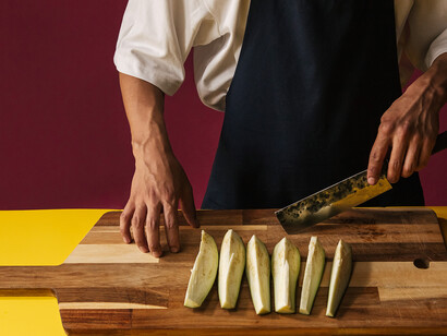 A skilled chef meticulously dicing eggplants with precision, preparing a delectable masterpiece known as "Hünkar Beğendi"